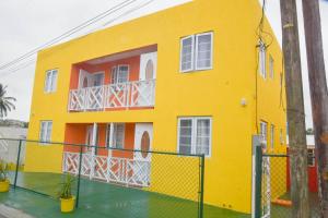 a yellow house with a fence in front of it at ZenBreak Grateful no2 1bd B in Bridgetown