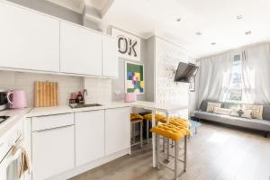 a kitchen with white cabinets and a table and chairs at Stylish flat in West Hampstead in London