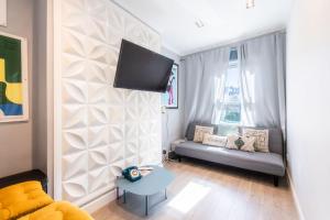 a living room with a couch and a tv on a wall at Stylish flat in West Hampstead in London