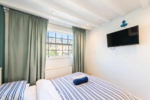 a bedroom with a bed and a flat screen tv at Stylish flat in West Hampstead in London +7 photos