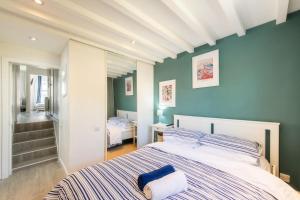 a bedroom with a large bed with blue walls at Stylish flat in West Hampstead in London