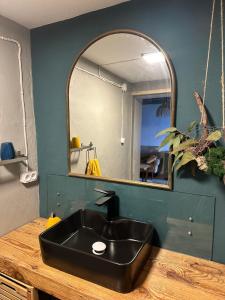ein Badezimmer mit schwarzem Waschbecken und Spiegel in der Unterkunft Casa de basalto in Caniço + 36 Fotos