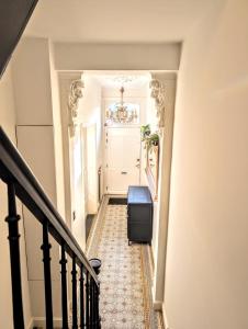 a hallway with a stairway with a suitcase at 't Herenhoes in Neerpelt
