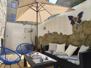 patio z kanapą, krzesłami i parasolem w obiekcie Casa O Castriño w mieście Cambados