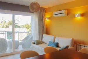 a living room with a white couch and a window at IQU Apart in Las Gaviotas