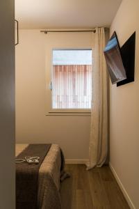 un dormitorio con una cama y una ventana en Alloggi Celly Appartamento piano terra, en San Vendemiano