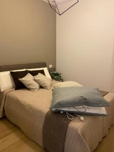 Una cama con almohadas en un dormitorio. en Alloggi Celly Appartamento piano terra, en San Vendemiano