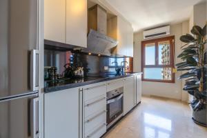 a kitchen with white cabinets and a stove at Marbella Port Beachfront - EaW Homes in Marbella +12 photos