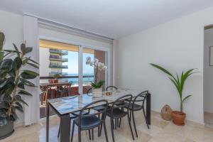 a dining room with a glass table and chairs at Marbella Port Beachfront - EaW Homes in Marbella