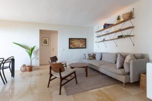 a living room with a couch and a table at Marbella Port Beachfront - EaW Homes in Marbella