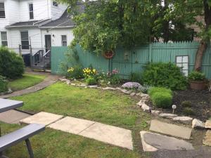 a yard with a fence and a garden with flowers at Walk to the Falls from The Mint in Niagara Falls