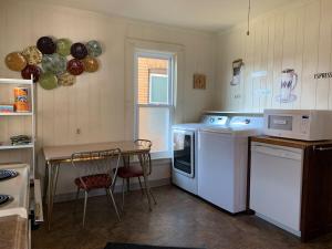 a kitchen with a table and a stove and a microwave at Walk to the Falls from The Mint in Niagara Falls