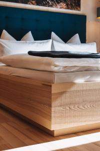 Una cama con sábanas blancas y almohadas. en tinnes apartments, en Schoppernau 62 fotos más