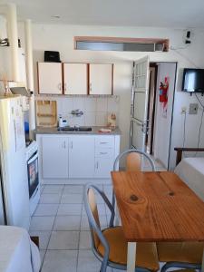 a small kitchen with a wooden table and a dining room at Leticia y Fabián in Gualeguaychú +28 photos