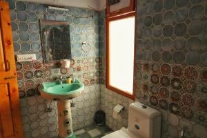 a bathroom with a sink and a toilet at Ailyak Stays and Cafe, Shoja, Jibhi in Shoja +72 photos
