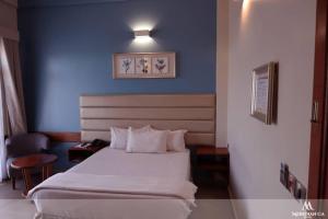 ダル・エス・サラームにあるMeridian CA Hotelのベッドルーム1室(青い壁の白いベッド1台付) +15枚の写真