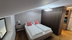 a bedroom with a bed with two pink pillows at Ferienwohnung Nahe Gmunden Top 3 in Pinsdorf