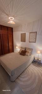 a bedroom with a large bed and two lamps at Maison Calme au Centre du Village in Puisserguier