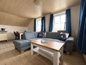 a living room with a couch and a table at Bensersiel Ferienwohnung Matrose mit Balkon und Garten in Bensersiel