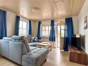 a living room with a couch and a tv at Bensersiel Ferienwohnung Matrose mit Balkon und Garten in Bensersiel
