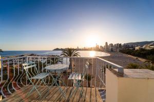 a balcony with chairs and a view of the beach at Apartamentos Brisas del Poniente in Benidorm