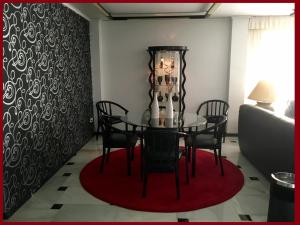a dining room with a table and chairs on a red rug at Hotel Albatros in Gandía