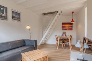 ein Wohnzimmer mit Sofa und Tisch in der Unterkunft Hello Zeeland - Vakantiehuis Beatrixstraat 27A in Domburg