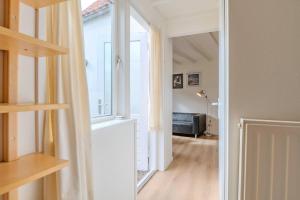 einen Flur mit Fenster und ein Wohnzimmer in der Unterkunft Hello Zeeland - Vakantiehuis Beatrixstraat 27A in Domburg + 13 Fotos