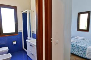 a bathroom with a sink and a toilet and a bed at Verdemare in Cefalù