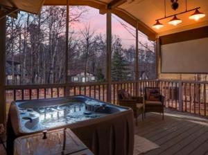 TobyhannaにあるPocono - Home away from homeのスクリーン付きのデッキにある大きな屋外浴槽