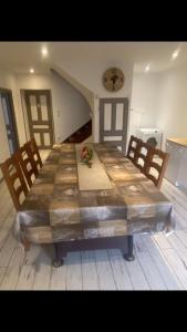un tavolo da pranzo con sedie e un grande tavolo di Maison à la campagne Grande cuisine tous équipés, grand salon , 3 chambres avec lits doubles, salle de bain et toilettes a Fournols