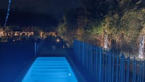 a swimming pool at night with a fence and trees at Ático loft en molino antiguo in Paterna