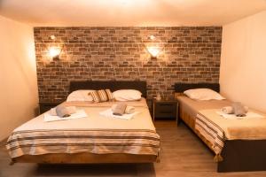 two beds in a room with a brick wall at Bakery apartments in Perea