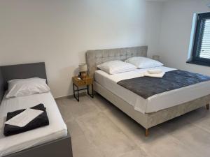 a bedroom with two beds and a table with a night stand at Villa Karla in Konjevrate +21 photos