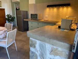 a kitchen with a counter with a microwave and a refrigerator at Borgo dell'Uccellaia - Quarzo in Marciana Marina