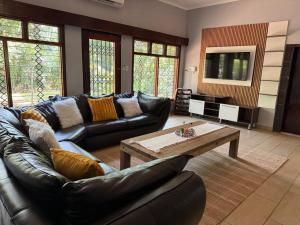 a living room with a leather couch and a coffee table at Emoyeni Malelane Lodge in Malelane