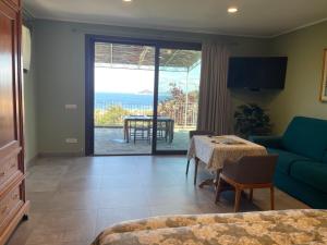 a living room with a room with a table and a couch at Borgo dell'Uccellaia - Quarzo in Marciana Marina