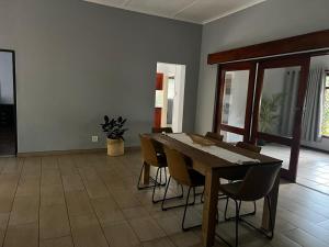 a dining room with a wooden table and chairs at Emoyeni Malelane Lodge in Malelane