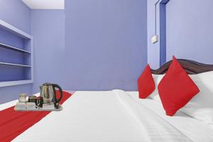 a bedroom with a bed with red and blue walls at Hotel O Stayz in Auroville