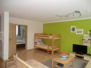 a living room with a green wall with bunk beds at Ferienwohnung Koch in Rust