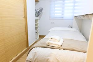 2 posti letto in camera con asciugamani sul letto di Apartamento pobla farnals playa precioso a Las Canteras Altre 20 foto