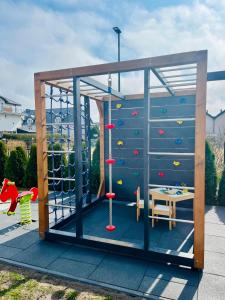 a play structure with a climbing wall and a playground at Karwia Marina Apartamenty in Karwia