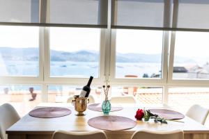 stół z butelką wina i kwiatami w obiekcie Covelodge - Piso a pocos metros de la playa w mieście Pontevedra