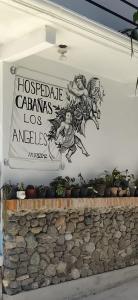 a sign on the side of a building with plants at Hospedaje 'Los Ángeles ' in Huasca de Ocampo +7 photos