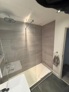 a bathroom with a glass shower with a sink at 5 Halifax House Apartment 7 in Liverpool +5 photos