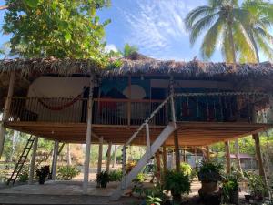a tree house with a thatched roof at Antigua "Hostel Playero" in Palomino