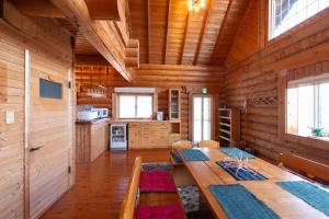 ein Esszimmer mit einem Tisch und einer Küche in der Unterkunft Beachfront Cabin in Suo Oshima