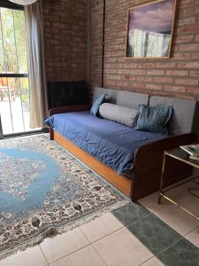 - un lit dans une chambre avec un canapé et une table dans l'établissement Casa Boreal dptos estilo casa, à Puerto Madryn