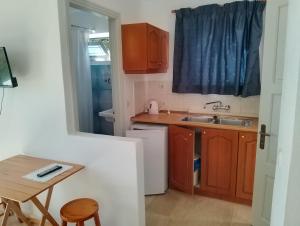 a small kitchen with a sink and a table at neptune resort apartments in Kavos