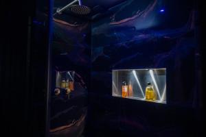 a dark room with two bottles of alcohol on a shelf at Baobab Logement Atypique avec jacuzzi privé in Corbas